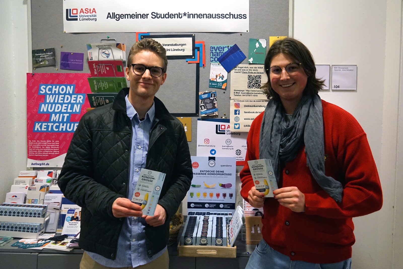 Luis Spondomsista (vasemmalla) avaa ilmaisen kondomiannostelijan yhdessä Maxin kanssa Leuphana University Lüneburgin AStA:sta (oikealla).